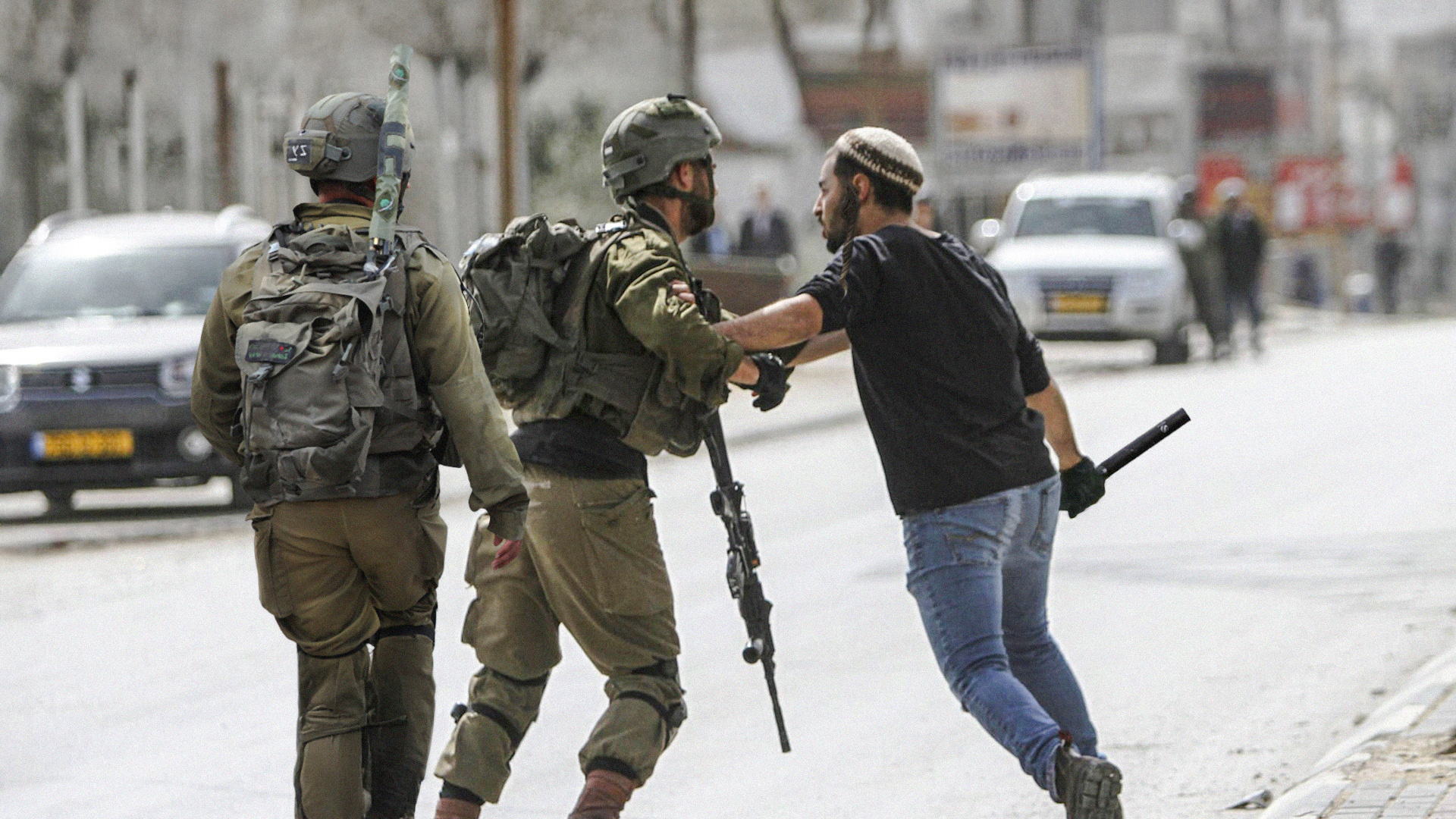 صورة مستوطن يهاجم جنوداً إسرائيليين بعد اعتقالهم جميع الفلسطينيين الذين كان ينوي قتلهم اليوم