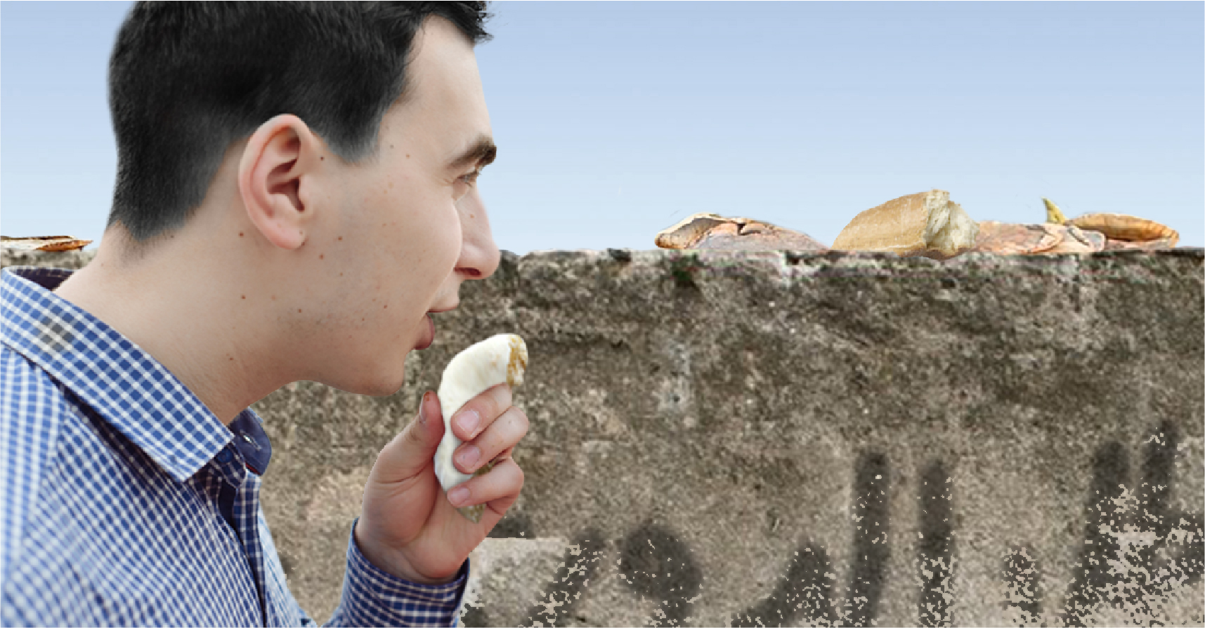 صورة شاب يخدش الحياء العام ويقبِّل قطعة خبز قبل أن يضعها على السور