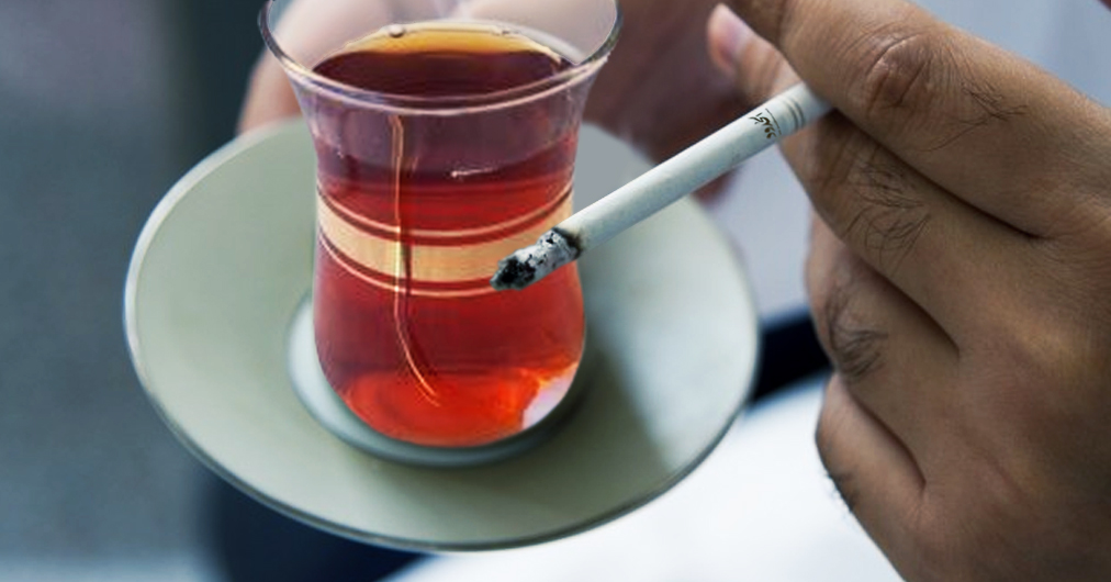 صورة شاب صحي يغيّر فطوره المكون من القهوة مع السيجارة بالشاي مع السيجارة