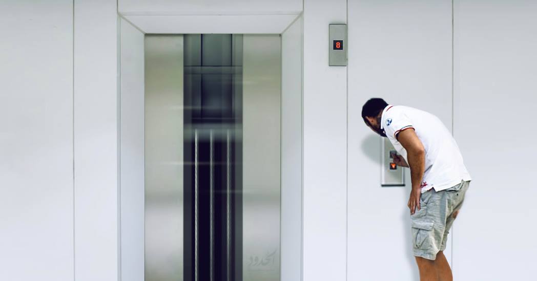 صورة شاب يقنع مصعداً بالقدوم بسرعة بعد ضغطه الزر عشر مرات متتالية