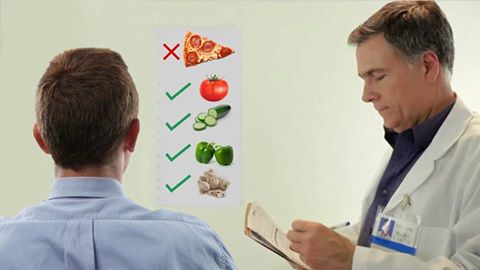صورة طبيب ينصح شاباً مصاباً بالبدانة بالحصول على مدخوله من الخضار من أطعمة غير البيتزا